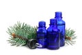 Different little bottles with essential oils and pine branches