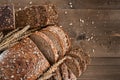 Different loaves of whole grain bread from the bakery are cut into pieces. Composition with seeds, sesame seeds and wheat ears. Royalty Free Stock Photo