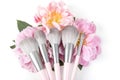 Different makeup brushes with pink peonies flowers on white background. Professional cosmetic makeup set. Royalty Free Stock Photo