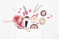 Different makeup cosmetic. Ball blush rouge lipstick concealer bottle of perfume makeup brush spring pink flowers in white gift