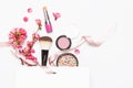 Different makeup cosmetic. Ball blush rouge lipstick concealer bottle of perfume makeup brush spring pink flowers in