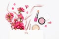 Different makeup cosmetic. Ball blush rouge lipstick concealer bottle of perfume makeup brush spring pink flowers in