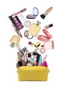 Different makeup products falling into beauty bag on white background. Decorative cosmetics Royalty Free Stock Photo
