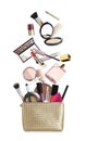 Different makeup products falling into beauty bag on white background. Decorative cosmetics Royalty Free Stock Photo