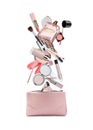 Different makeup products falling into beauty bag on white background. Decorative cosmetics Royalty Free Stock Photo