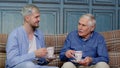 Different male generations family of senior father and adult son or grandson relaxing, drinking tea Royalty Free Stock Photo