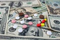 Different medical pills on the background of dollars