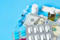 Different medicaments and money on blue background. Medical concept. Doctor salary. Corruption in healthcare Royalty Free Stock Photo