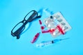 Different medicaments near glasses on blue background