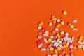 Different medicine pills, tablets on orange background. Many medicine pills and tablets with place for text. Health care. Top view Royalty Free Stock Photo