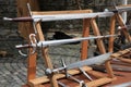 Different medieval styled swords on wooden racks