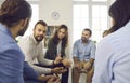 Different men and women at support group meeting listen to young man talking about himself. Royalty Free Stock Photo