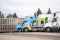 Different model of big rigs semi trucks with different semi trailer stand on truck stop parking place Royalty Free Stock Photo