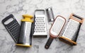 Different modern graters on white marble table, flat lay Royalty Free Stock Photo