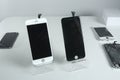 Different modern mobile phones with broken screen on white table Royalty Free Stock Photo