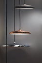 Different modern streamlined mirror copper chandeliers. Metal copper disk shaped pendant lamps. Loft style