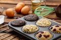 Different Muffins in bakeware or muffin pan on broun wooden background. Basic muffin recipe. Homemade muffins for breakfast or des