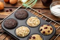 Different Muffins in bakeware or muffin pan on broun wooden background. Basic muffin recipe. Homemade muffins for breakfast or des