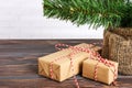 Different New Year& x27;s gifts wrapped in wrapping paper under the Christmas tree branch