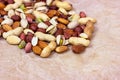 Different nuts: almonds, pistachios, peanuts, hazelnuts heap on light background.