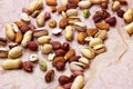 Different nuts: almonds, pistachios, peanuts, hazelnuts heap on light background.