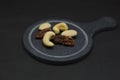 Different Nuts on a plate in front of black Background Royalty Free Stock Photo