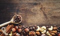 Different nuts on a wooden table. Cedar, cashew, hazelnut, walnuts and a spoon on the table. Many nuts are inshell and Royalty Free Stock Photo