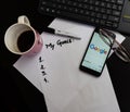 Different objects on black office desk. Paper with my goals, keyboard, phone, glasses, cup of coffee