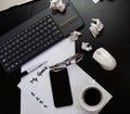 Different objects on black office desk. Paper with my goals, keyboard, phone, glasses, cup of coffee