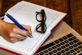 Different objects on wooden office desk. Modern wooden office desk table with laptop keyboard, black glasses, office agenda. Royalty Free Stock Photo