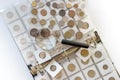 Different old collector`s coins with a magnifying glass, blurred background