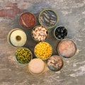 Different open canned food on old wooden background. Royalty Free Stock Photo
