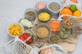 Different organic foods in glass jars and bowls on a white wooden background. Shopping and storage products. Top view. Copy space.