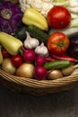 Different Organic Fruits and vegetables in basket on wooden table back Royalty Free Stock Photo