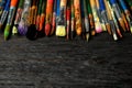 Different paint brushes on wooden table, closeup.