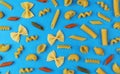 Different pasta types on blue background, top view, flat lay composition Royalty Free Stock Photo