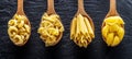 Different pasta types in wooden spoons on the table. Top view.