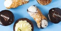 Different pastries on blue background: cannoli with ricotta, tartlets filled with citrus cream, fudge cake, tiramisu cake.