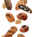 Different pastries with poppy seeds falling on background