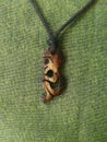 Primitive human or a baby on necklace