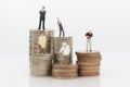 Different people standing on stack coins, using as salaries are different from many occupations concept Royalty Free Stock Photo