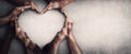 Different people unite for a common purpose as diverse person hands join together and create heart shape,  on grey wall Royalty Free Stock Photo