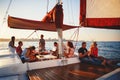 Different people at the yacht excursion in sea, summer sunset