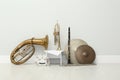 Different percussion and wind musical instruments near white wall indoors