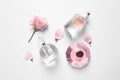 Different perfume and flowers on white background, top view