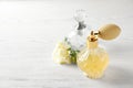 Different perfume bottles and flowers on white background, space for text Royalty Free Stock Photo