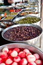 Different pickled olives in brine in market