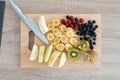 Different pieces of fresh fruits on a wooden board for cutting. Healthy food concept