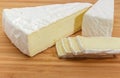 Partly sliced brie cheese on wooden cutting board close-up Royalty Free Stock Photo