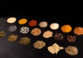 Different piles of spices isolated on black stone plate plaque. Place for text copy space Royalty Free Stock Photo